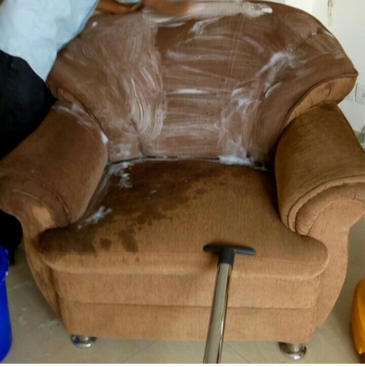 scrubbing couch with cleaning detergents